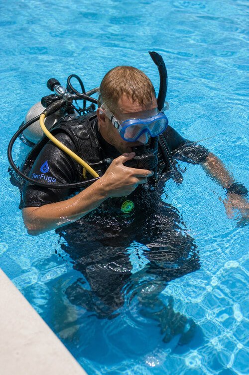 Mergulhador a realizar deteção de fugas em piscina com equipamento profissional subaquático