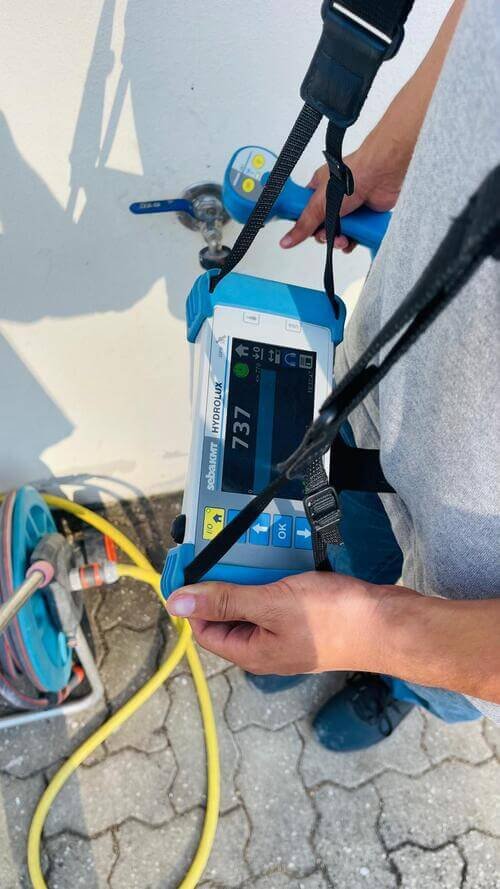 Técnico da TecFuga a utilizar um detetor de gás rastreador para localizar com precisão uma fuga de água numa tubagem, permitindo identificar o ponto exato da anomalia antes da reparação.