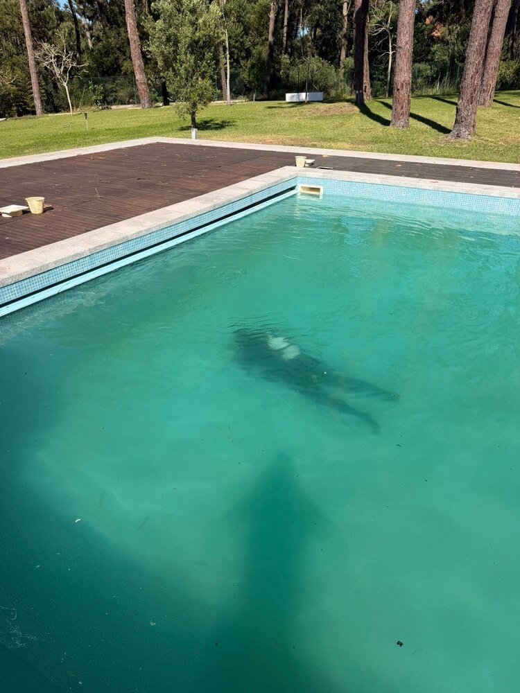 Técnico da Tec Fuga a realizar mergulho de inspeção subaquática na piscina para verificar o skimmer e localizar a origem da fuga de água através de métodos de inspeção não destrutivos.