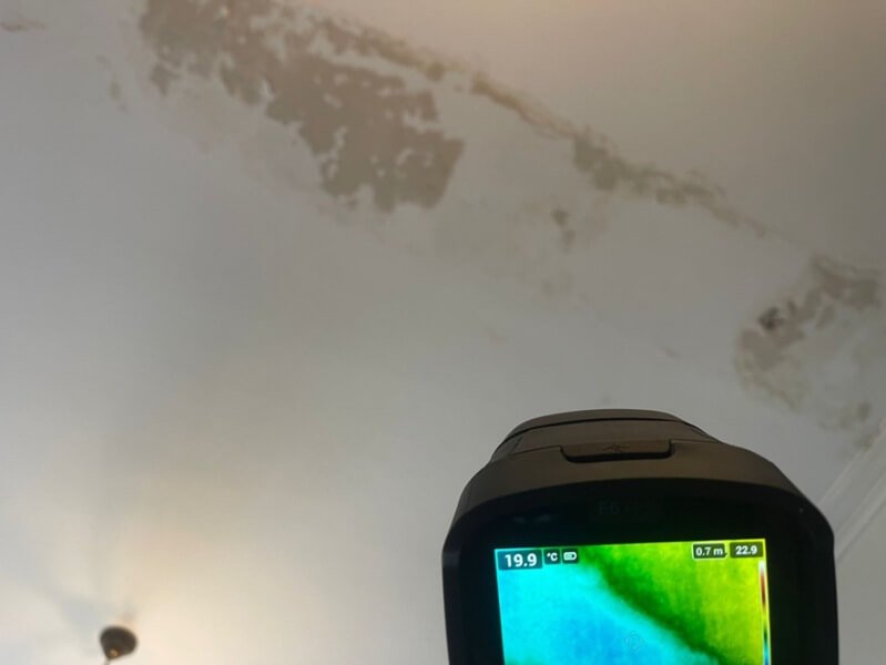 Inspeção com câmara termográfica evidencia uma zona de infiltração no teto causada por uma fuga na tubagem de esgoto, permitindo um diagnóstico não destrutivo.